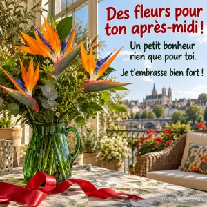 Un bouquet de strelitzias orange et bleus accompagne un ruban de cadeau sur une table ensoleillée, avec le texte « Des fleurs pour ton après-midi ! Un petit bonheur rien que pour toi. Je t’embrasse bien fort ! ».