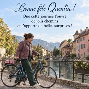 Une femme pousse un vélo bleu portant un paquet rose au bord d’un canal d’Annecy, avec le texte « Bonne fête Quentin ! Que cette journée t’ouvre de jolis chemins et t’apporte de belles surprises ! ».