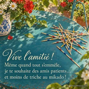 Des baguettes de mikado colorées s’entrecroisent sur une table de jardin alsacien, avec le texte « Vive l’amitié ! Même quand tout s’emmêle, je te souhaite des amis patients… et moins de triche au mikado ! ».