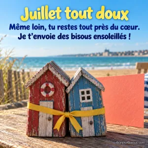 Deux petites cabines de plage en bois rouge et bleu se penchent l’une vers l’autre, réunies par un ruban jaune, avec le texte « Juillet tout doux Même loin, tu restes tout près du cœur. Je t’envoie des bisous ensoleillés ! ».